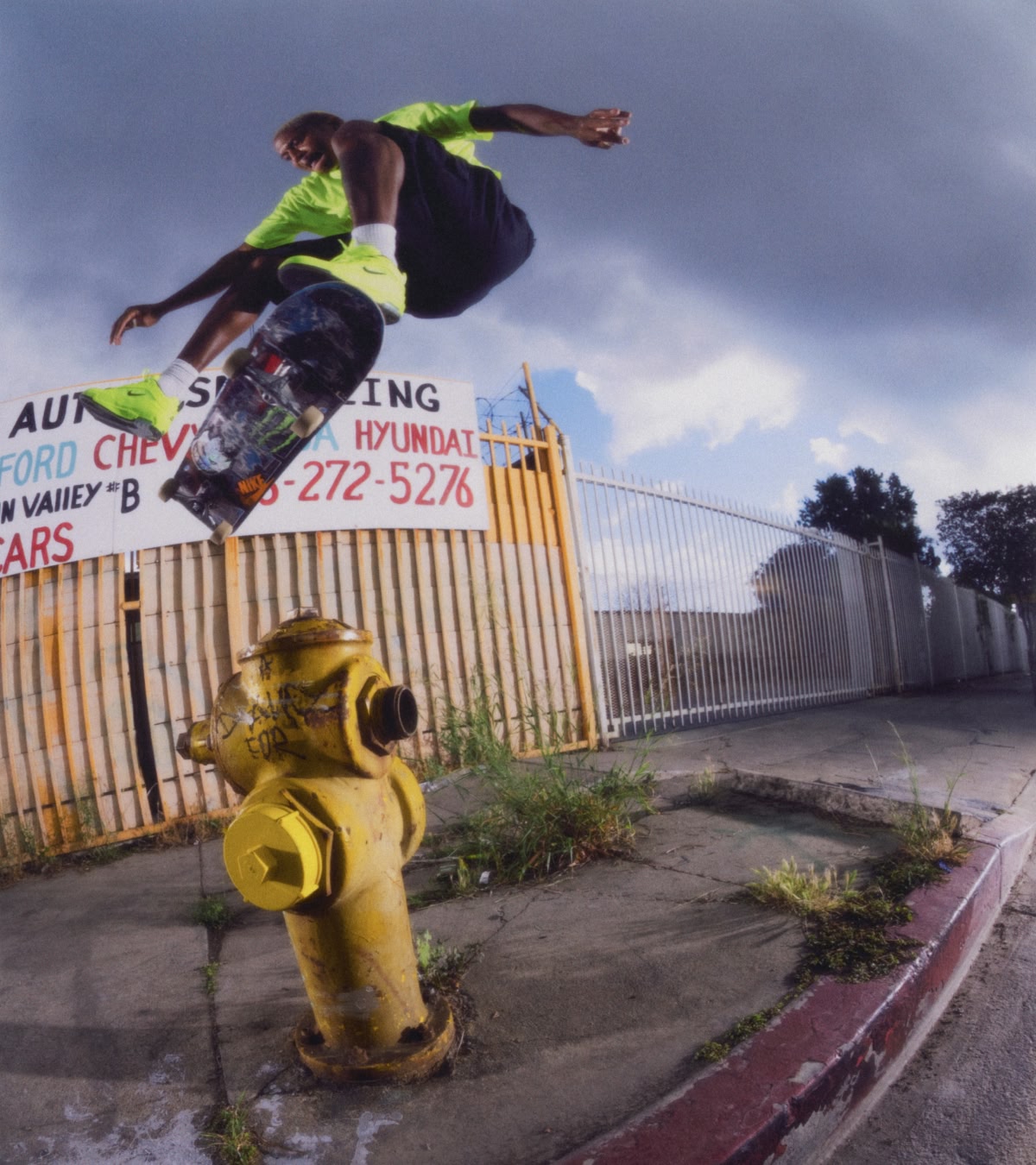 Shop the Nike SB Air Max Ishod Premium Volt | A man jumping a skateboard over a fire hydrant