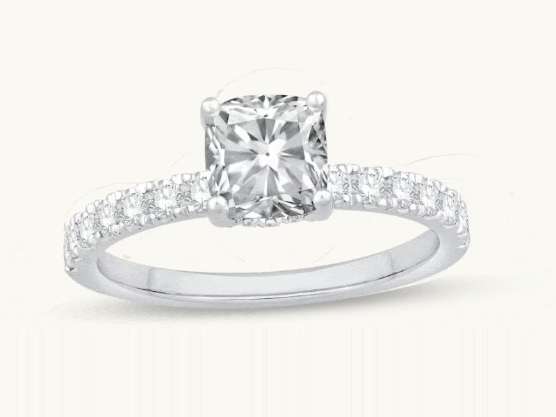 Rotating images of three rings: cushion-cut, oval-cut diamond rings with pavé diamonds on eternity bands.