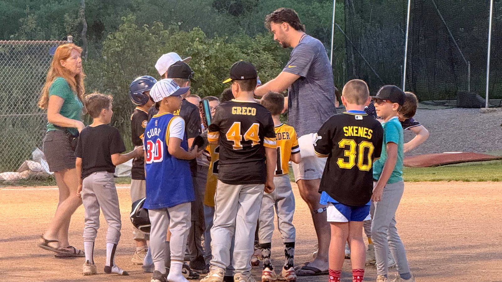 Paul Skenes among a group of Little Leaguers on a ballfield