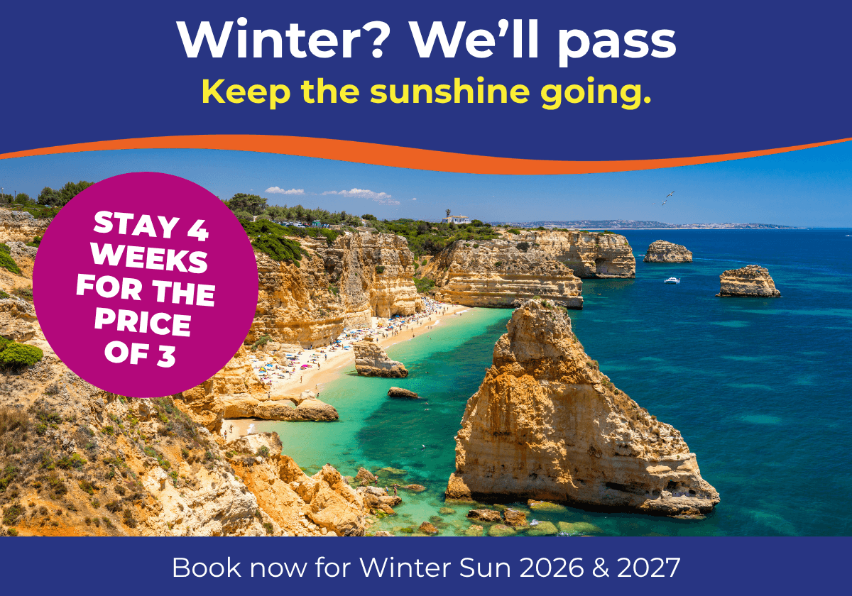 A scenic beach view with golden cliffs and turquoise waters, inviting winter sun seekers.