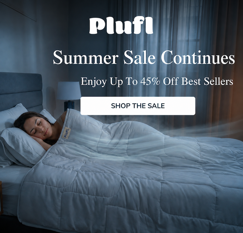 Woman sleeping peacefully under a comforter on a bed with a window in the background.
