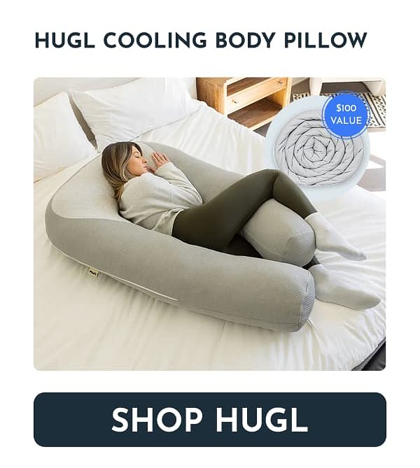 A woman sleeping comfortably with a large gray body pillow on a bed.