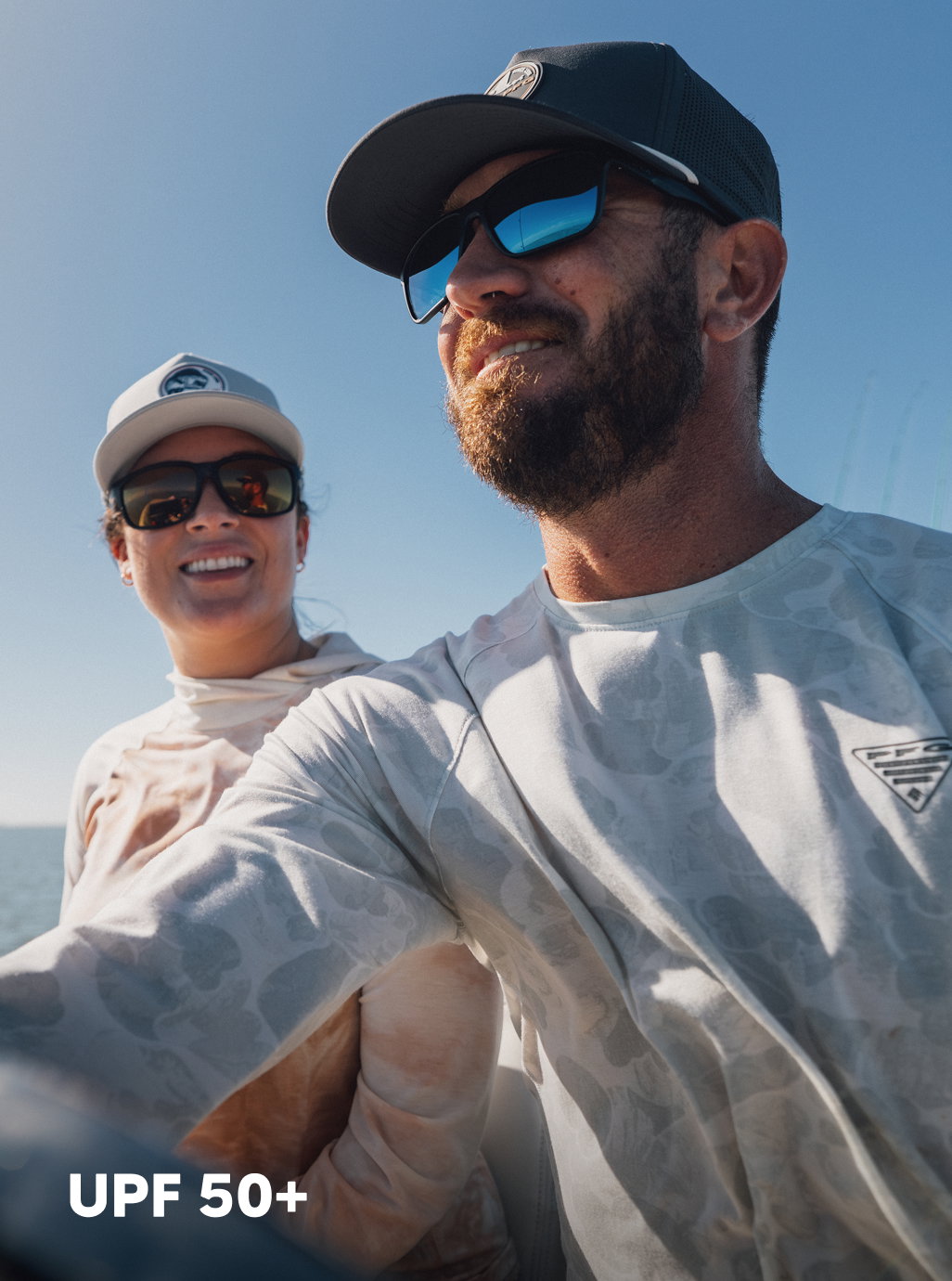 Headline: UPF 50+. A man and woman drive a boat.