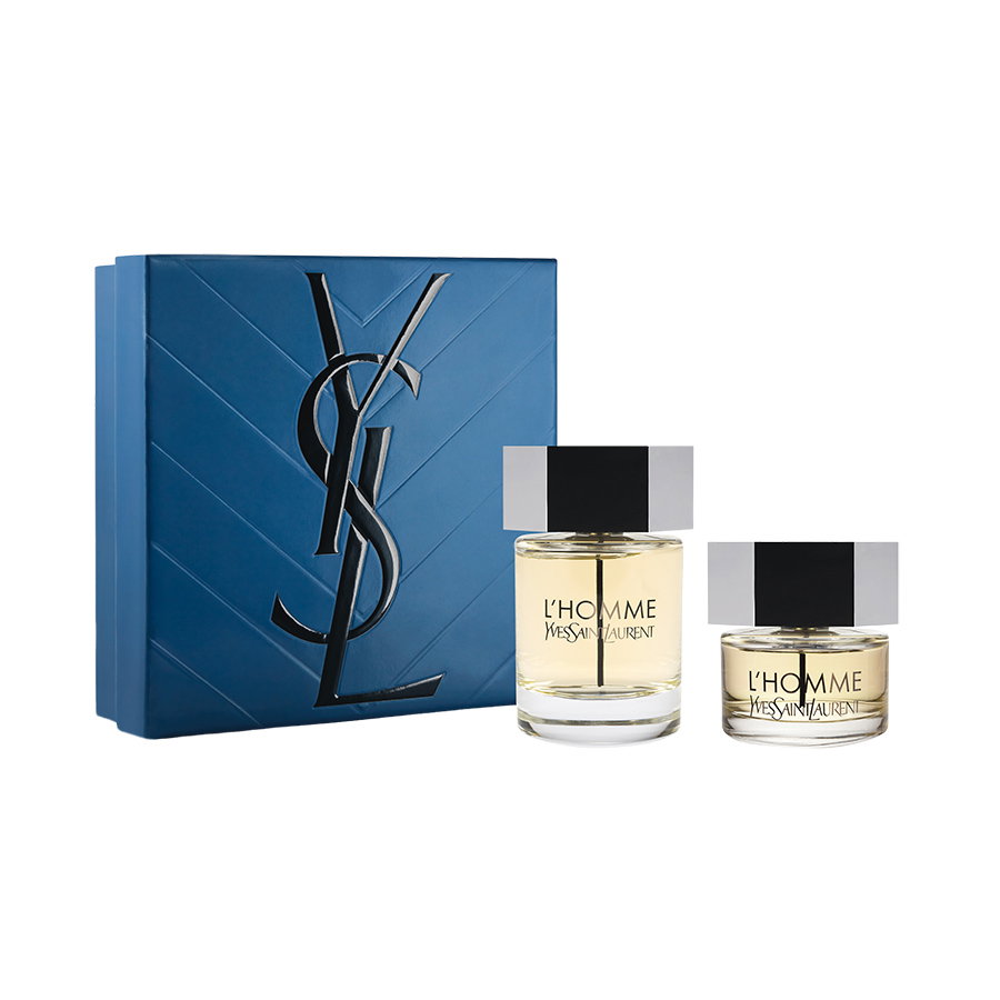 A luxury blue gift set embossed with a black YSL logo, presented alongside two bottles of Yves Saint Laurent L'Homme fragrance.