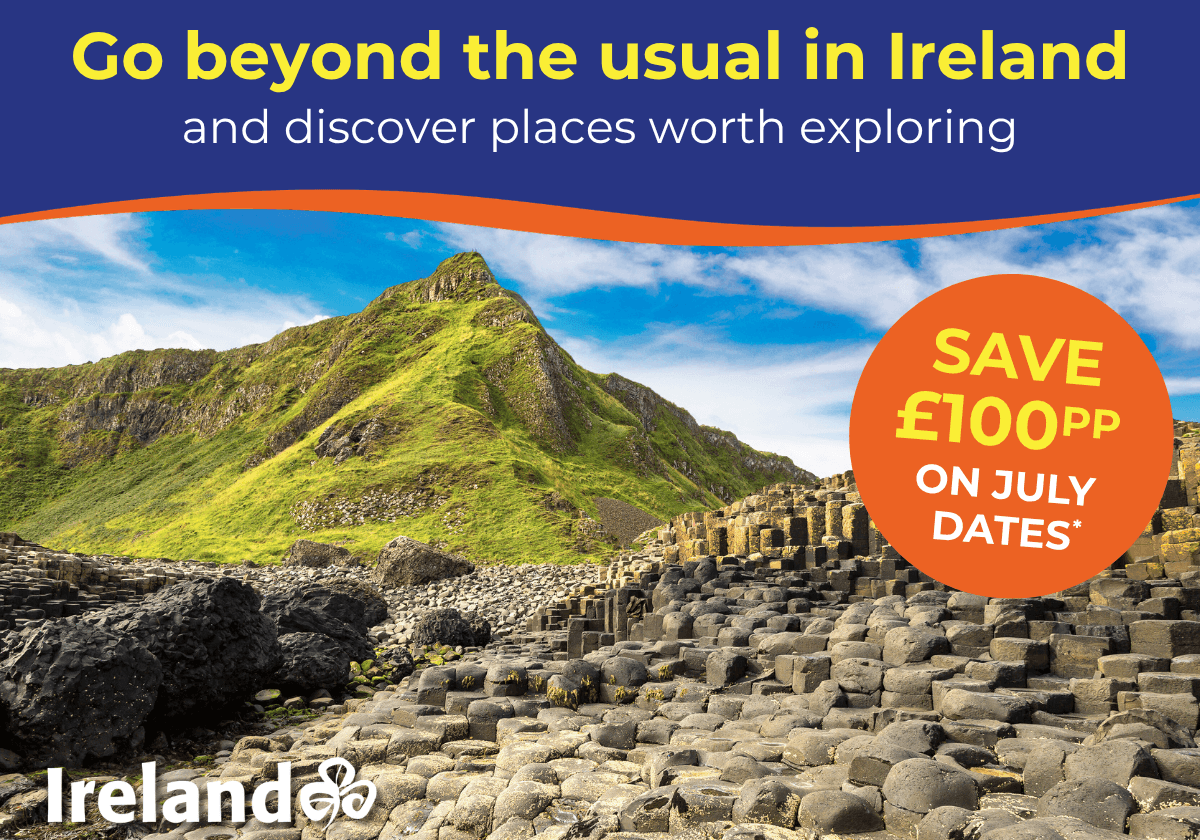 Scenic view of green hills and unique rock formations in Ireland under a blue sky.