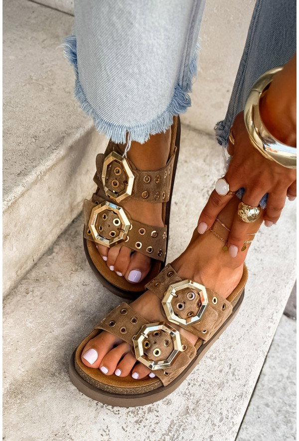 Brown suede double-strap sandals with oversized gold hex buckles, light pink pedicure, frayed-hem jeans and gold rings