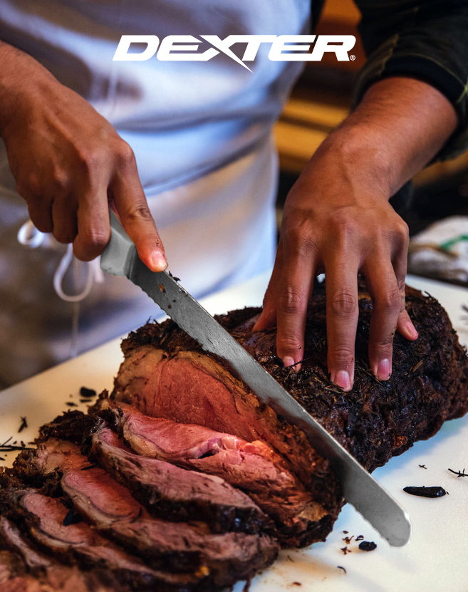 A chef slicing through a brisket using a Dexter Sani-Safe Slicer Knife on a white cutting board.
