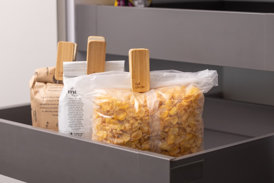 Three bags in a drawer with bamboo bag clips keeping them shut