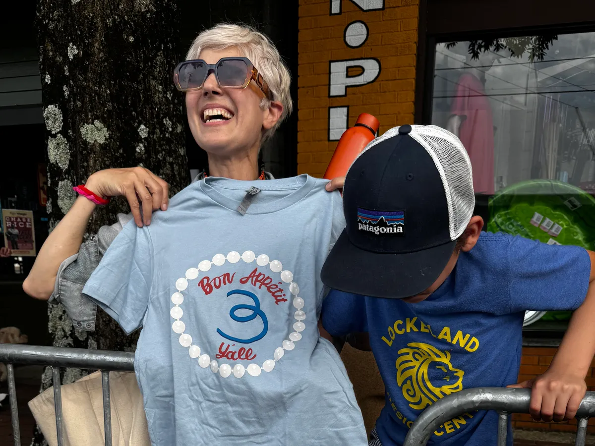 Louisa Shafia, with her son Dante, shows off some of the Margot merchandise she secured during the Five Points farewell event.