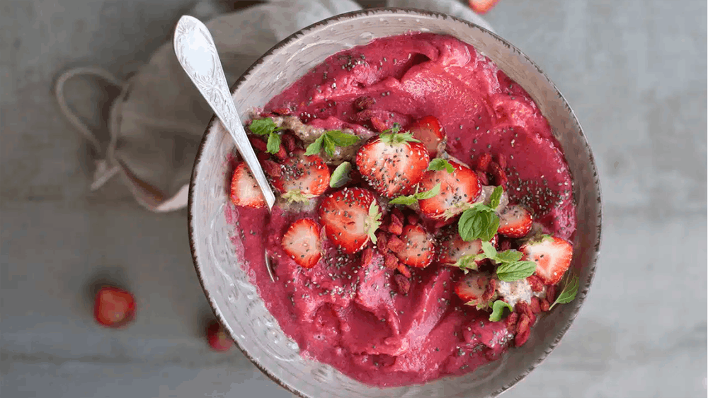 a bowl filled with fruit and topped with a spoon