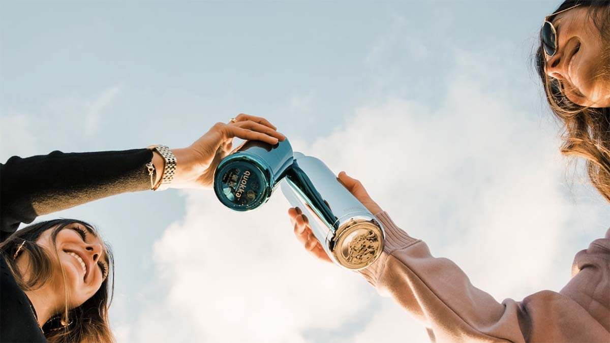 two women holding up a bottle of water