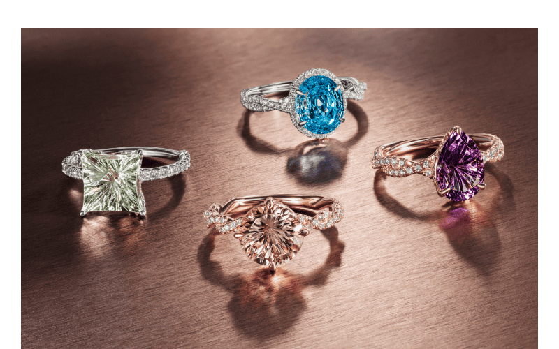 Colored gemstone rings featuring green quartz, blue topaz, morganite, and purple amethyst stones.