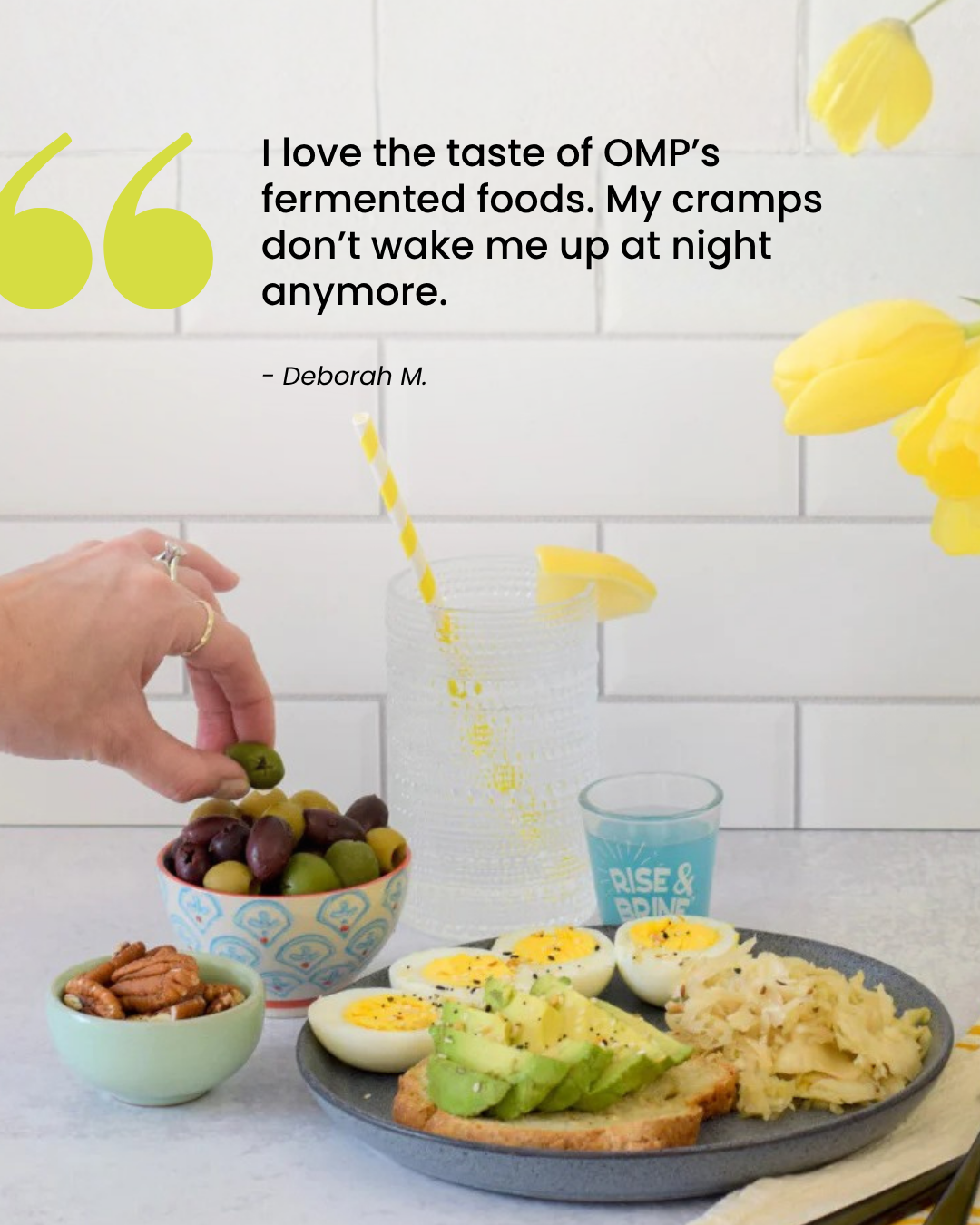 Close-up of a hand selecting an olive from a bowl, surrounded by a healthy meal including avocado toast, boiled eggs, and sauerkraut, with testimonial text abov
