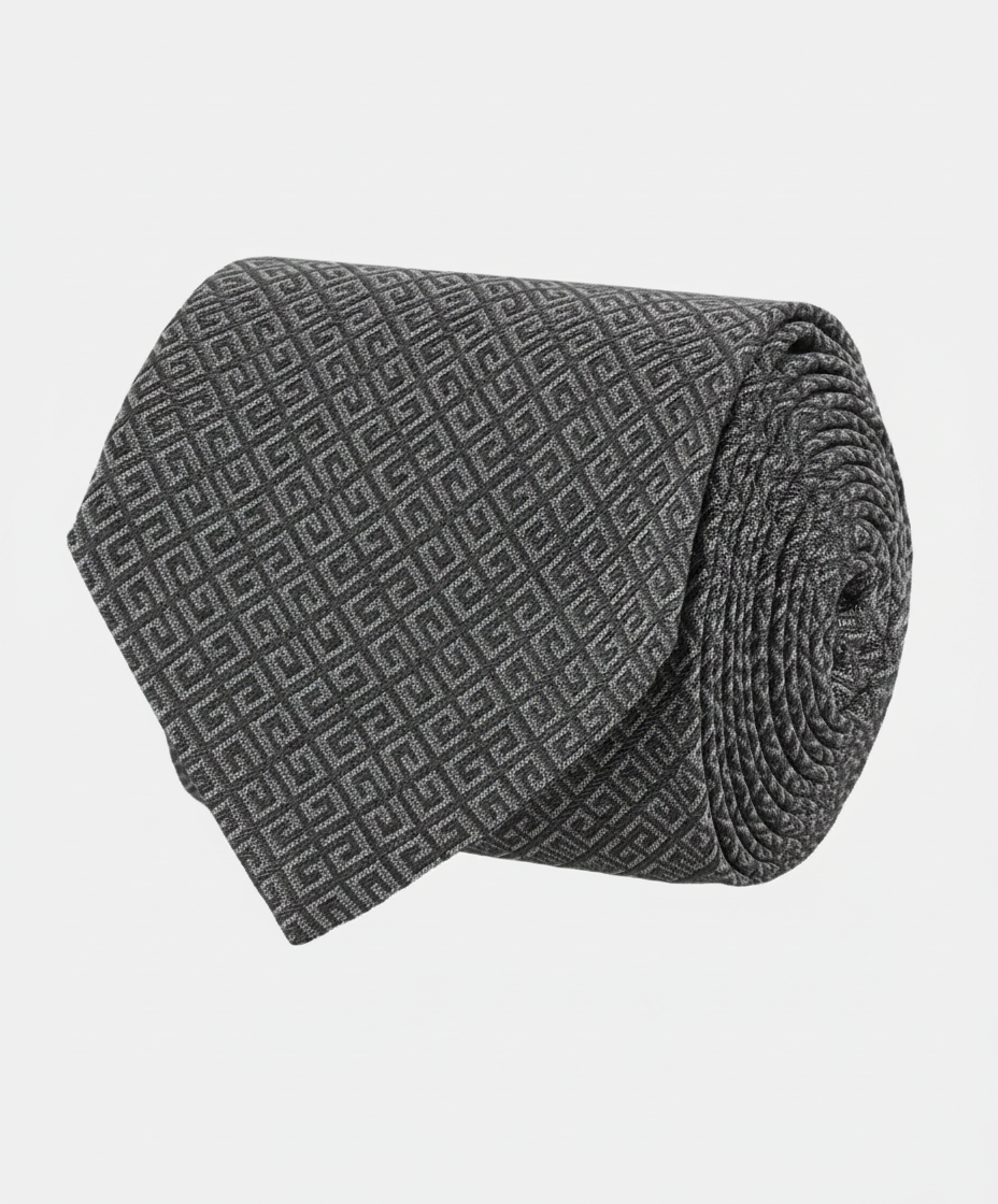 A rolled-up dark gray tie with a geometric pattern.