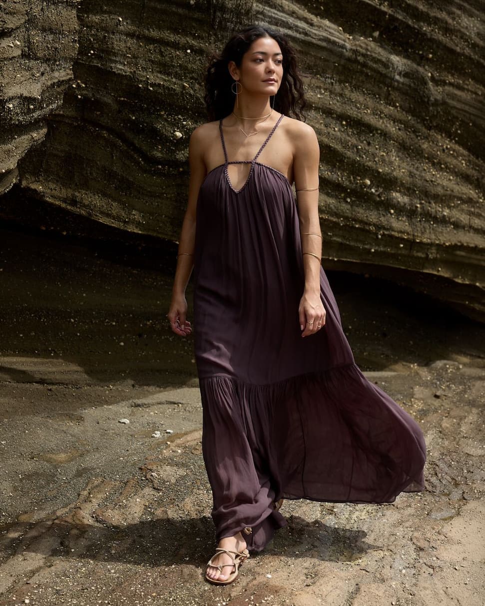 Women wearing a long brown dress walking on rocks