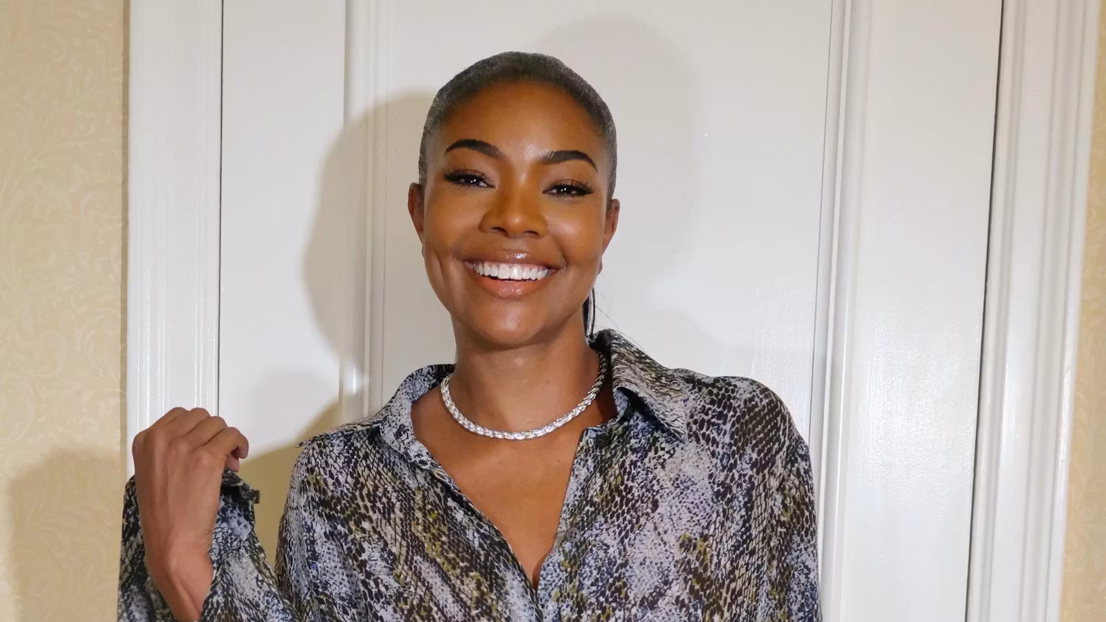 Gabrielle Union, standing in front of a door smiling