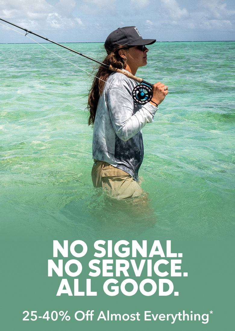 Woman standing waist deep in water with her fishing rod. Headline reads No Signal. No Service. All Good. 