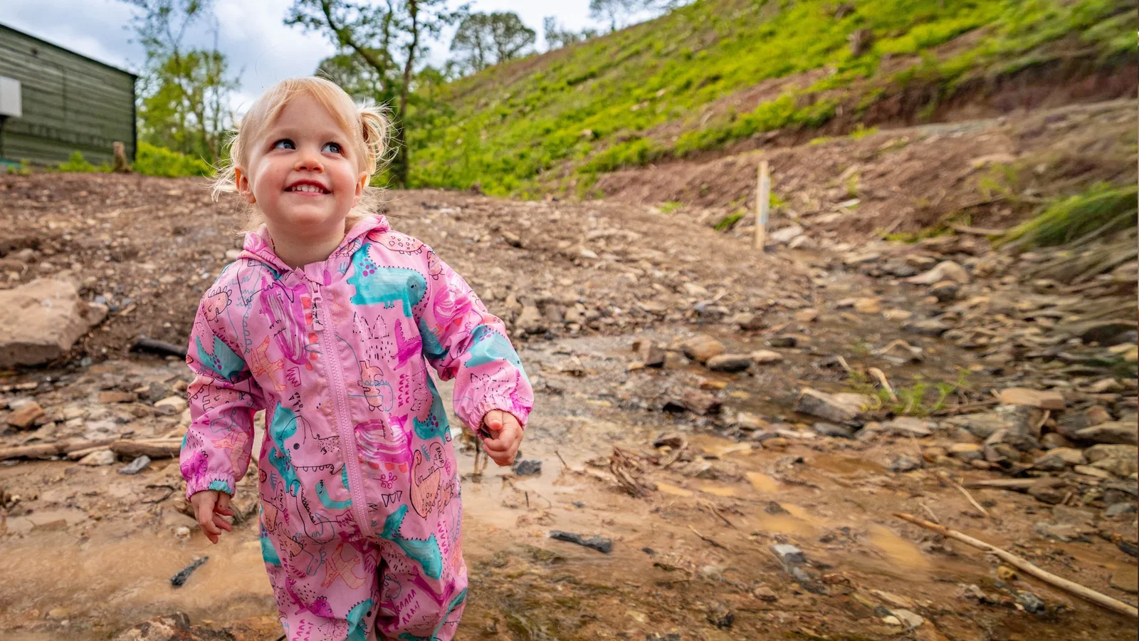 young girl playing at mud mission down the steep ravine