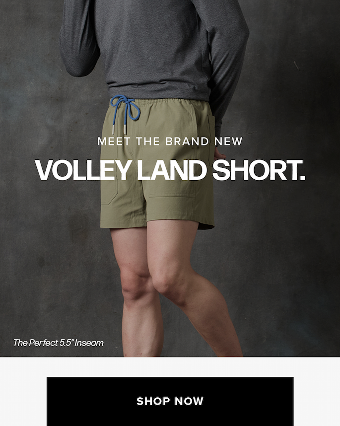 A person from the waist down wears light green shorts with a blue drawstring and a grey shirt against a dark grey wall. Text reads: 'Meet The Brand New Volley Land Short. The Perfect 5.5" Inseam Shop Now'