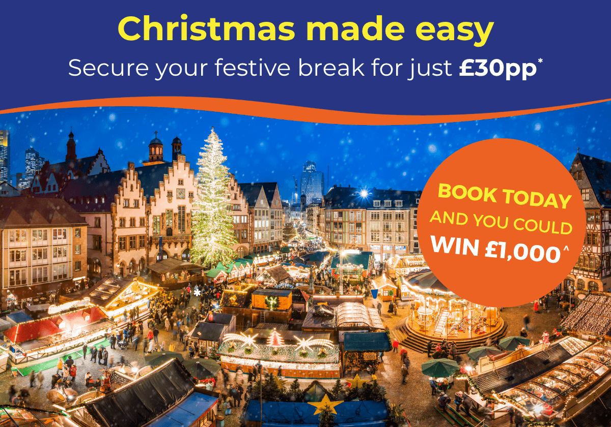 A festive Christmas market scene with twinkling lights, stalls, and a large decorated tree.