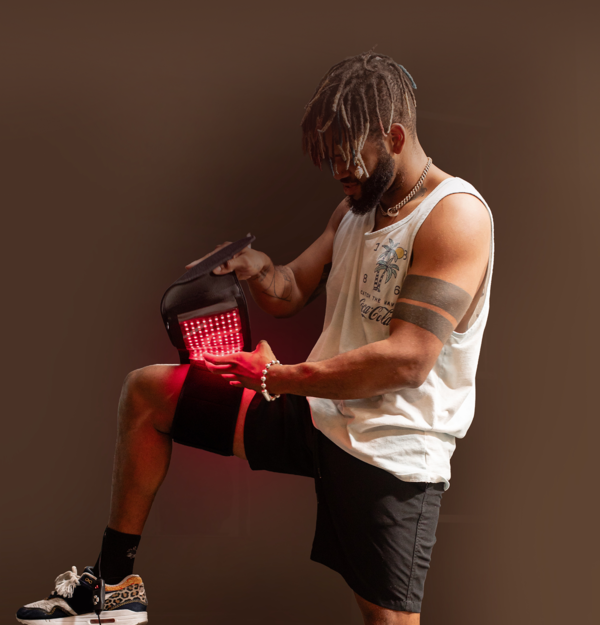Man uses the MitoQUAD for red light therapy on his quad.