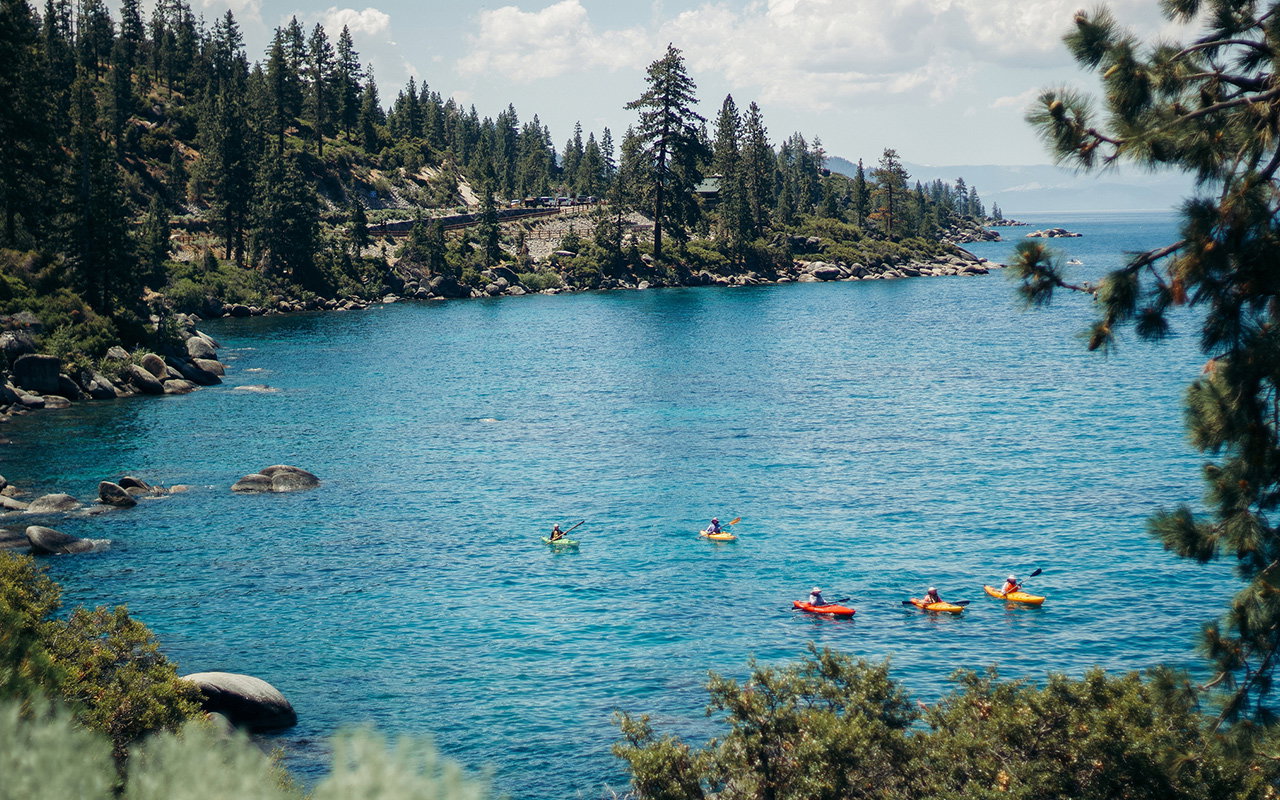 Colorful paddle boarders on the bright blue waters of Lake Tahoe