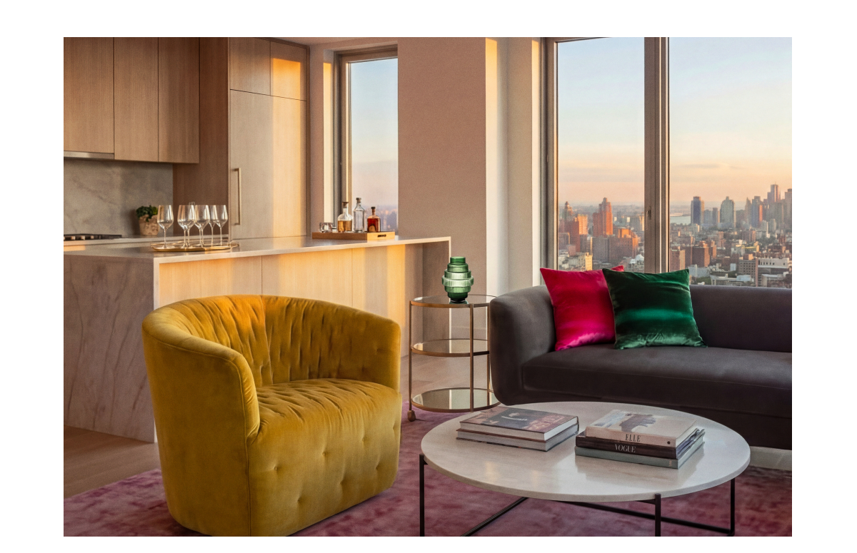 Living room with swivel chair, sofa, and coffee table overlooking the Manhattan skyline