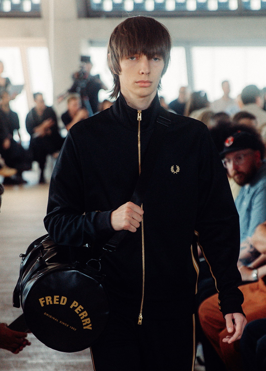 Male model wearing a Fred Perry Stripe Tape Track Jacket in Black / Champagne