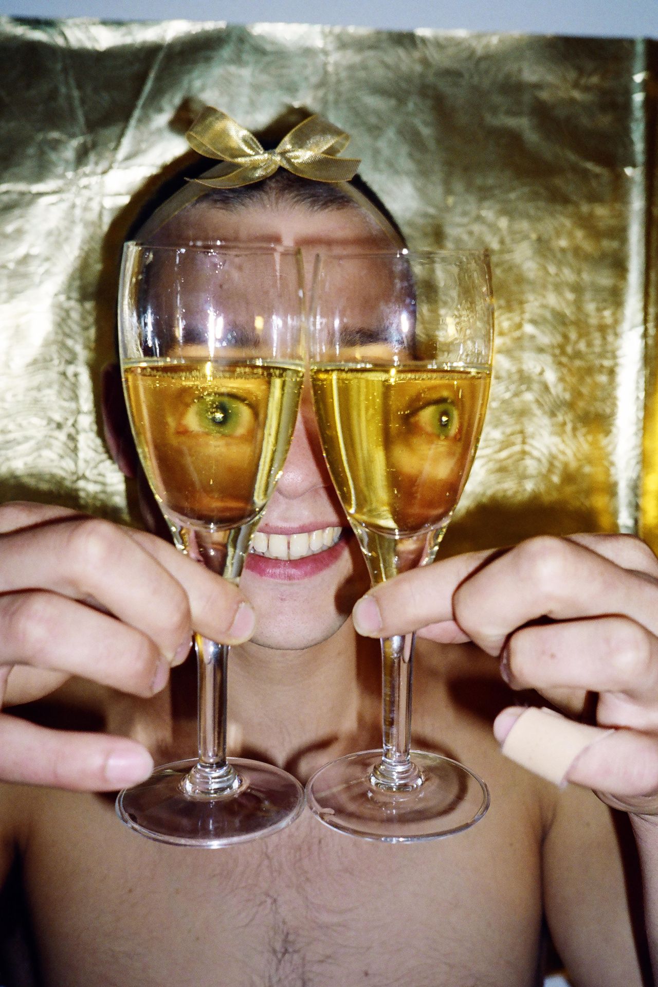 Man's eyes seen through two wine glasses