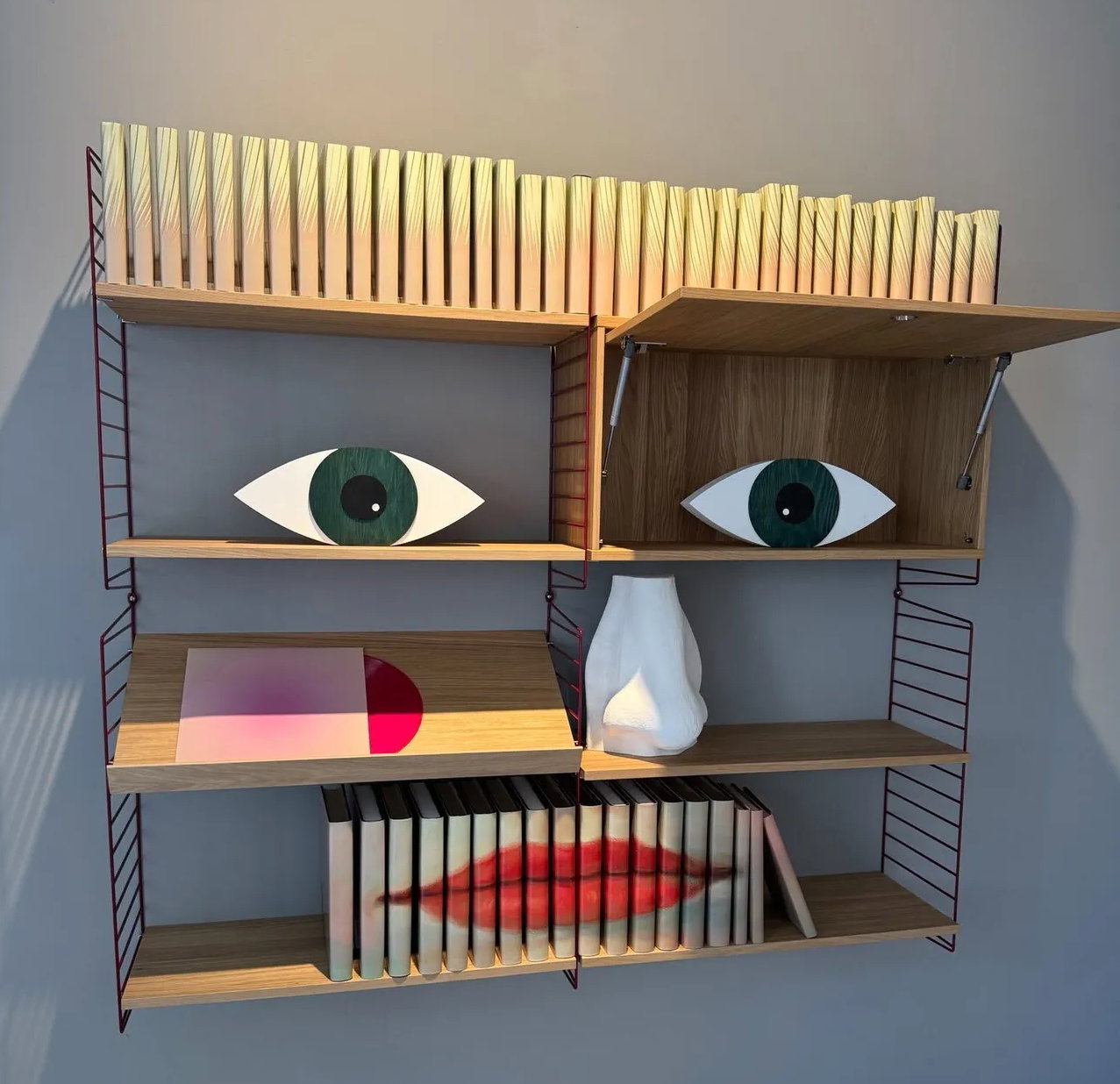Objects arranged on shelves to make a face, display from 3 Days of Design 2026