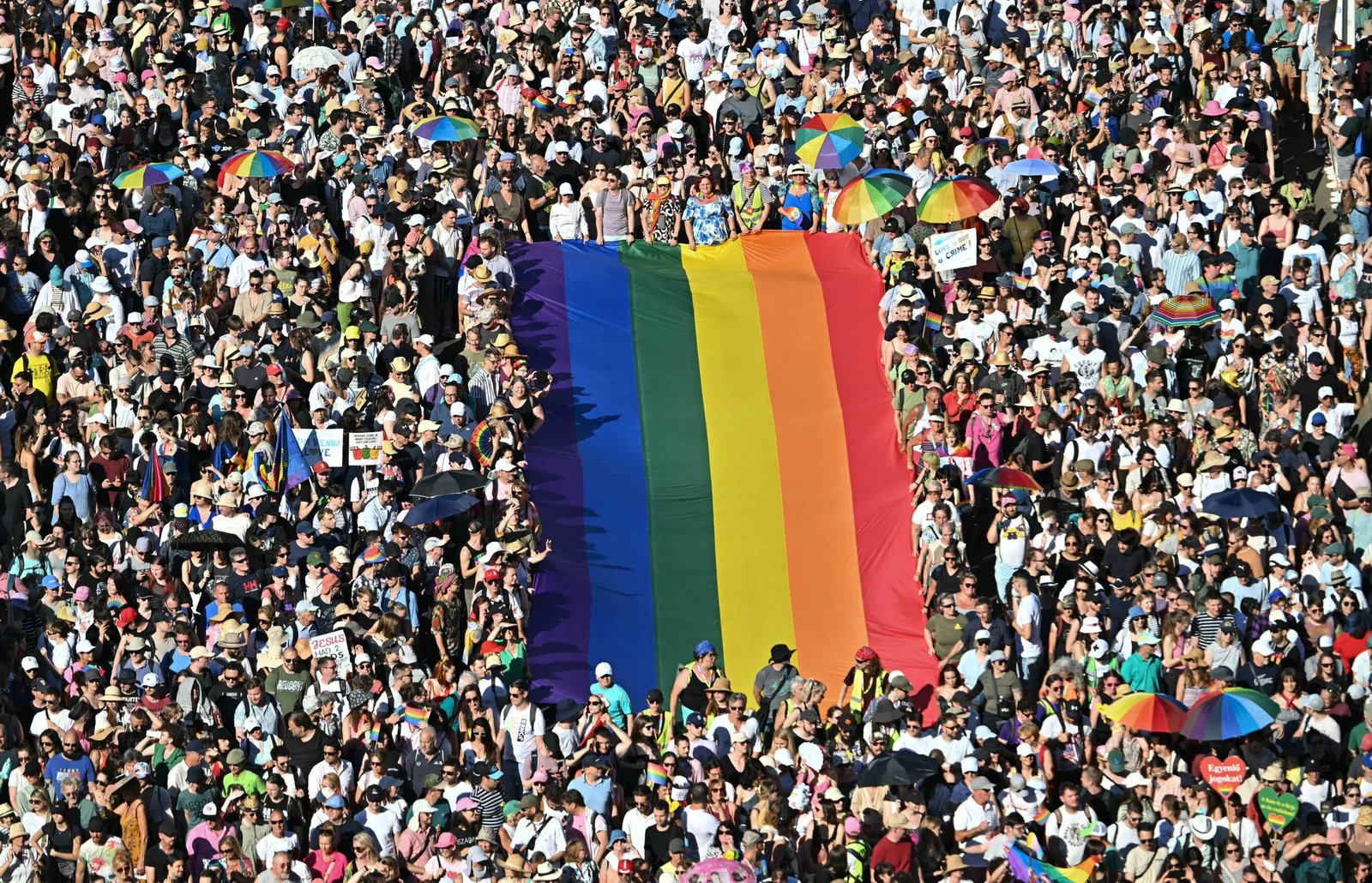 Large rainbow pride flag in the middle of a massive crowd
