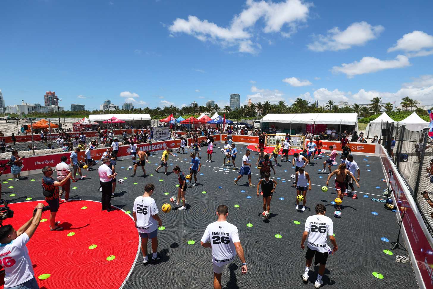 People spread out on soccer field juggling soccer balls
