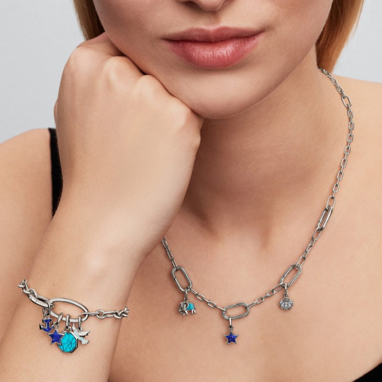 A model wears a sterling silver Pandora ME link chain bracelet and necklace with blue charms.