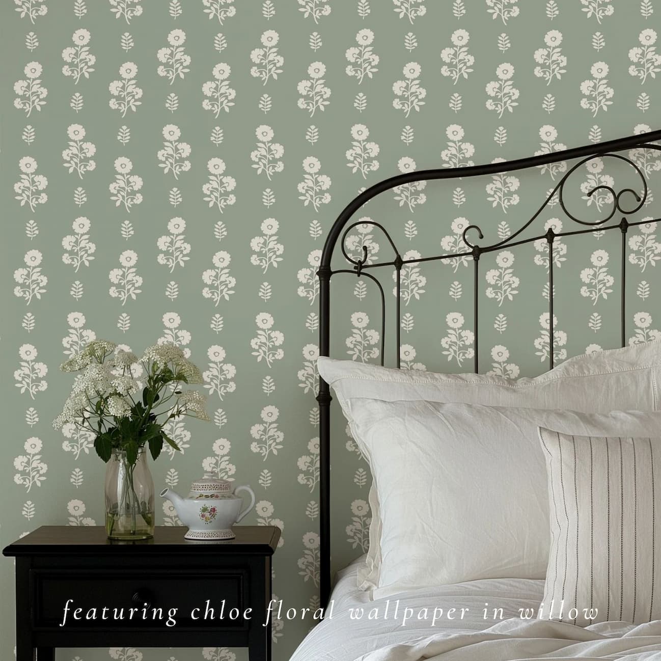 Chloe Floral wallpaper in willow in bedroom with metal bed frame.