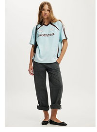 Woman wearing light blue graphic tee and charcoal pants