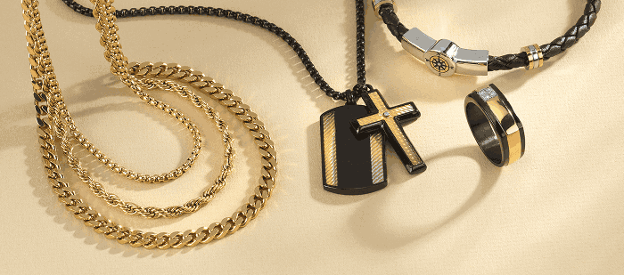 Men's jewelry featuring gold-tone chains, a black and gold cross pendant, a leather bracelet, and a matching band ring.