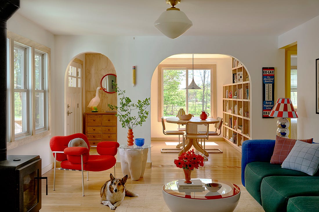 A red chair and green couch in an airy living room A red chair and green couch in an airy living room