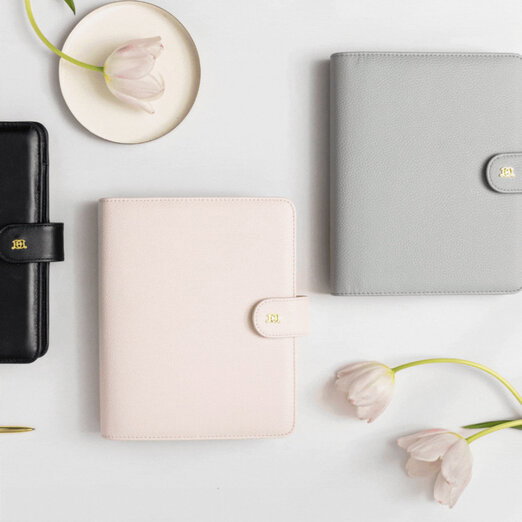 rotating images of A5 planners, shown in black, gray, pink colors