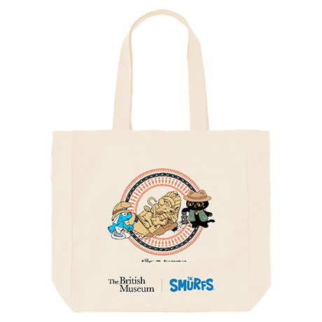 Large organic cotton tote bag featuring a playful illustration of Bastet watching Archaeology Smurf carefully uncover a pharaoh-inspired Smurf statue in the sand. - Shop Now.