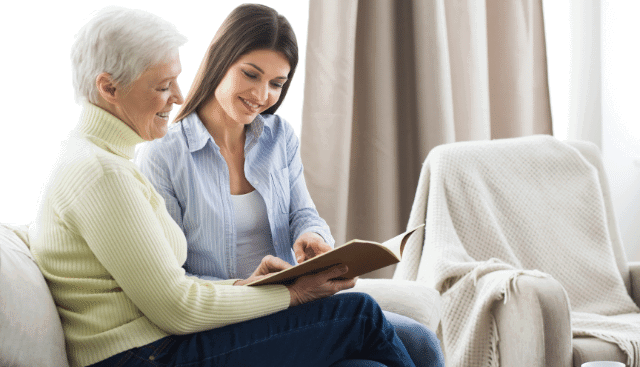 Woman and grandmother looking at a family photo album.