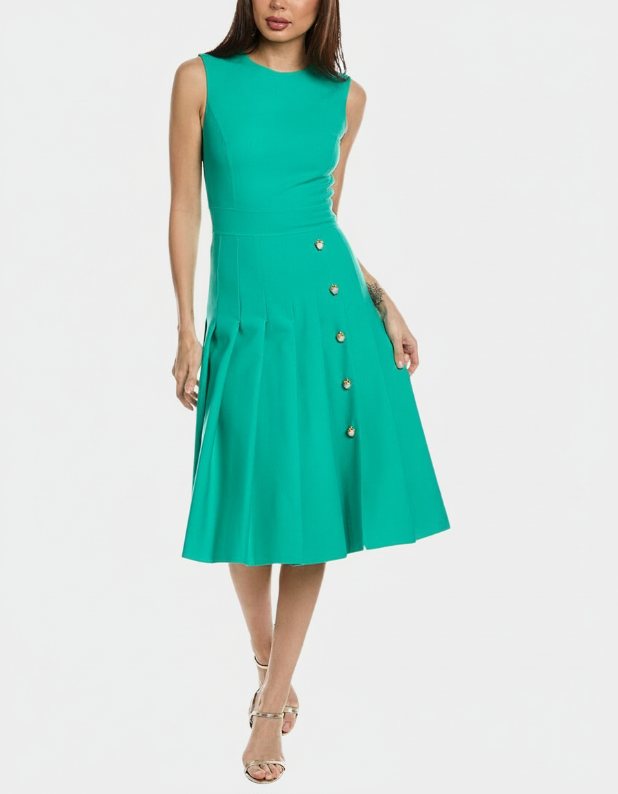 Woman in a sleeveless green midi dress with gold heart buttons and pleated skirt.
