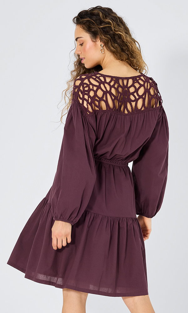 Frauenmodel trägt Kleid, Lila, langärmlig, Spitzenmuster am Rücken, Taillengummizug, Rückansicht