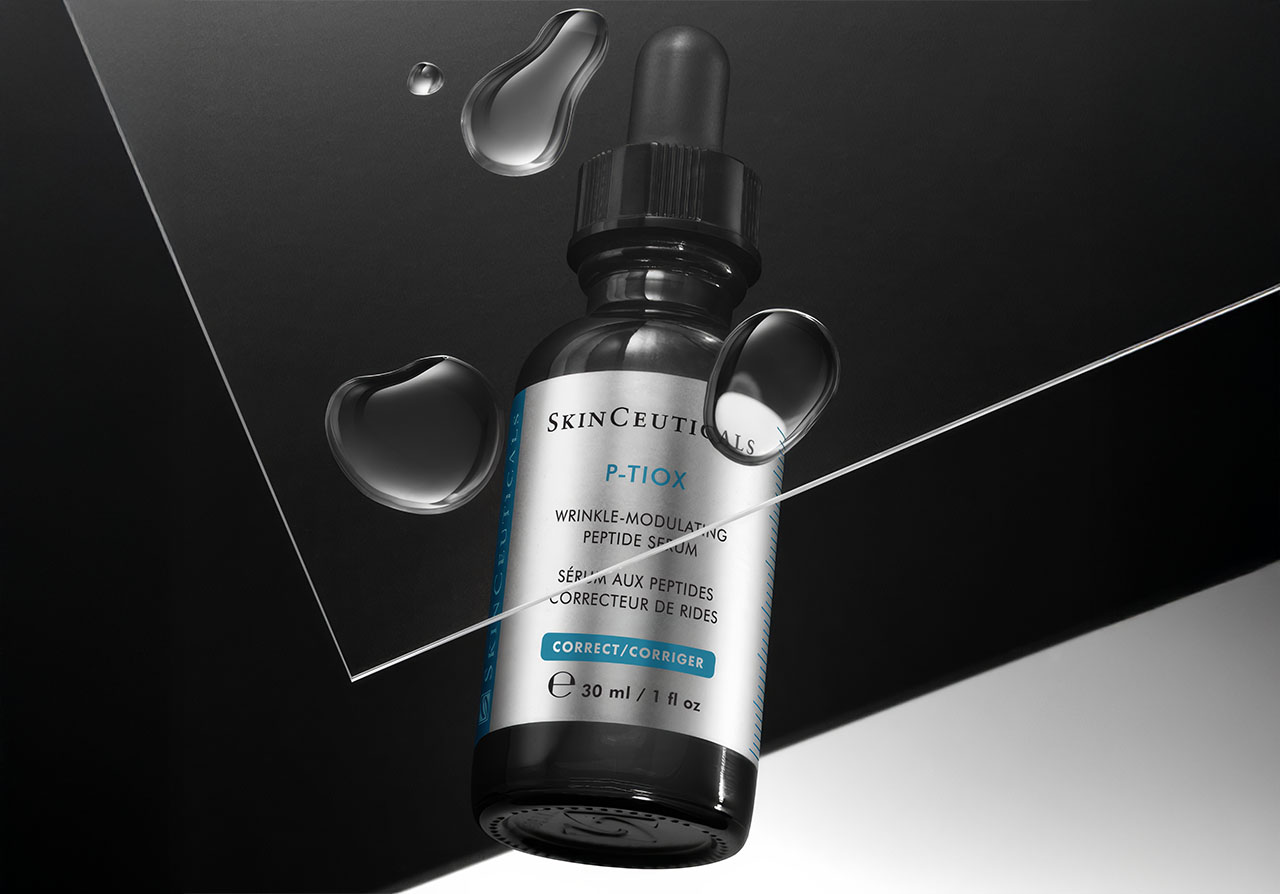 P-TIOX Serum auf modernem schwarzem Hintergrund mit Wassertropfen