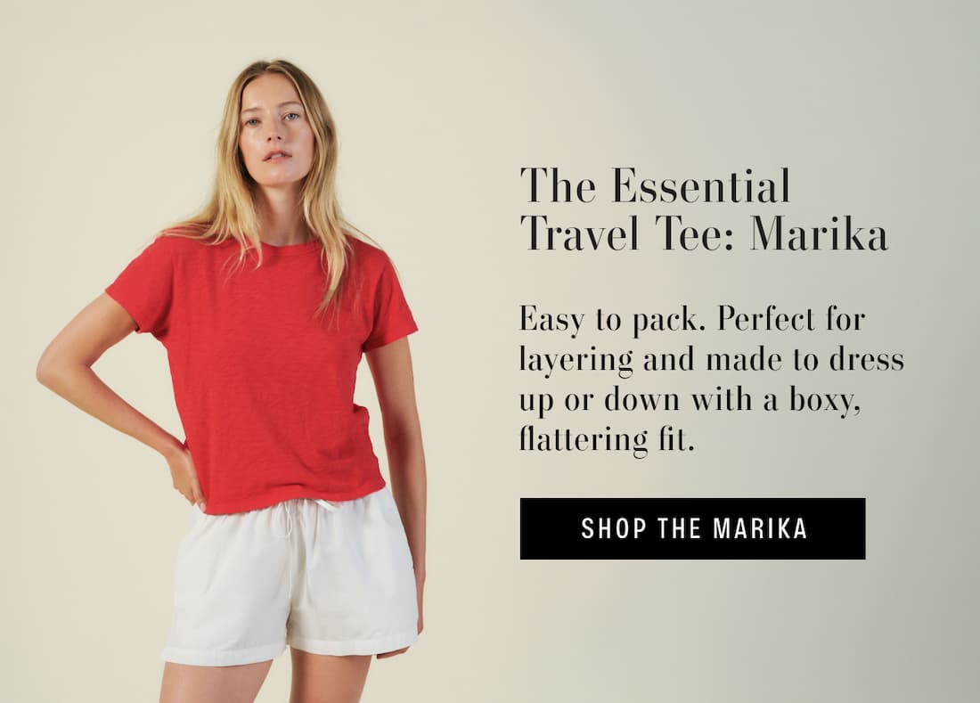 Image of model wearing marika top in Rio. Text reads: The Essential Travel Tee: Marika. Easy to pack. Perfect for layering and made to dress up or down with a boxy, flattering fit.