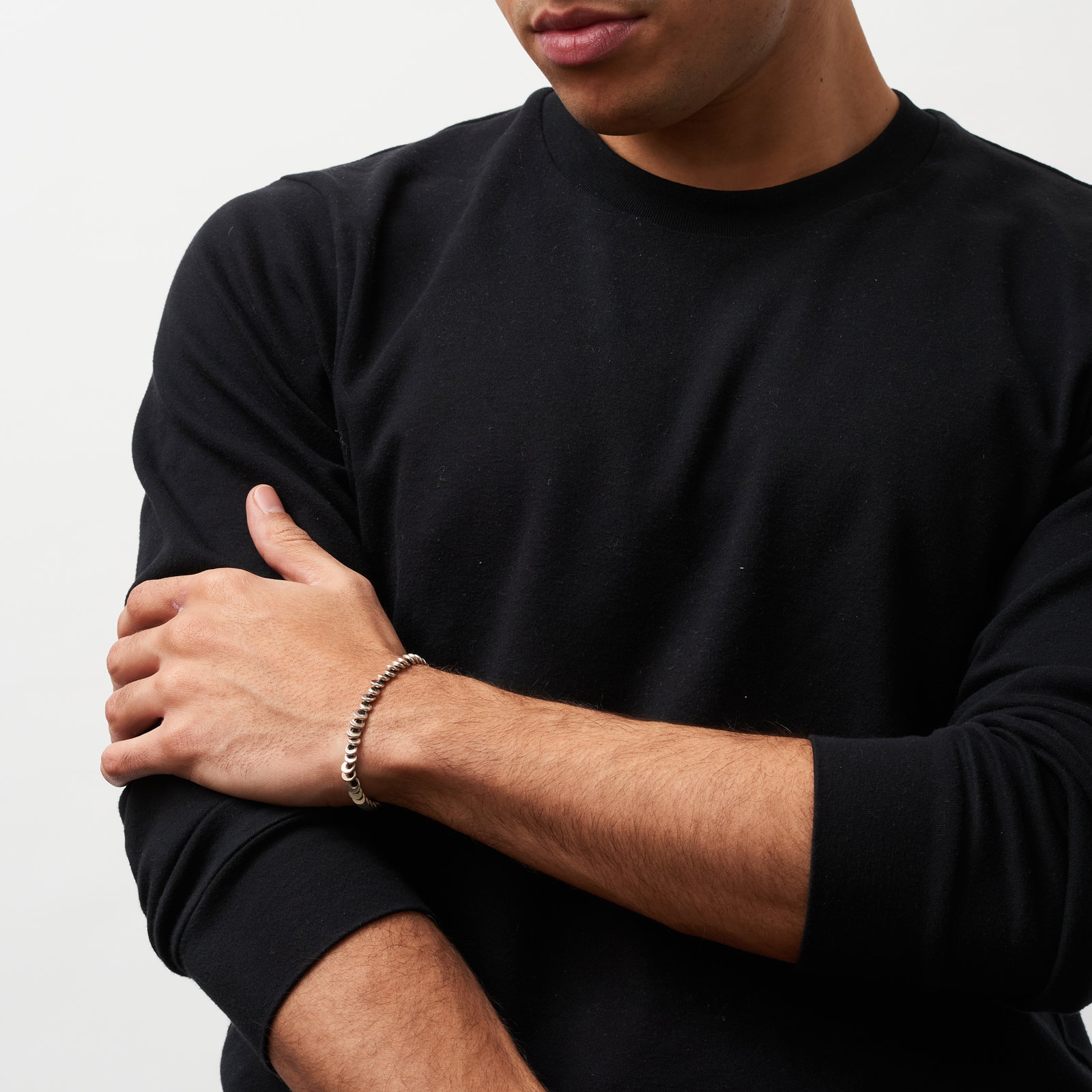 Men's wrist wearing sculptural silver bracelet