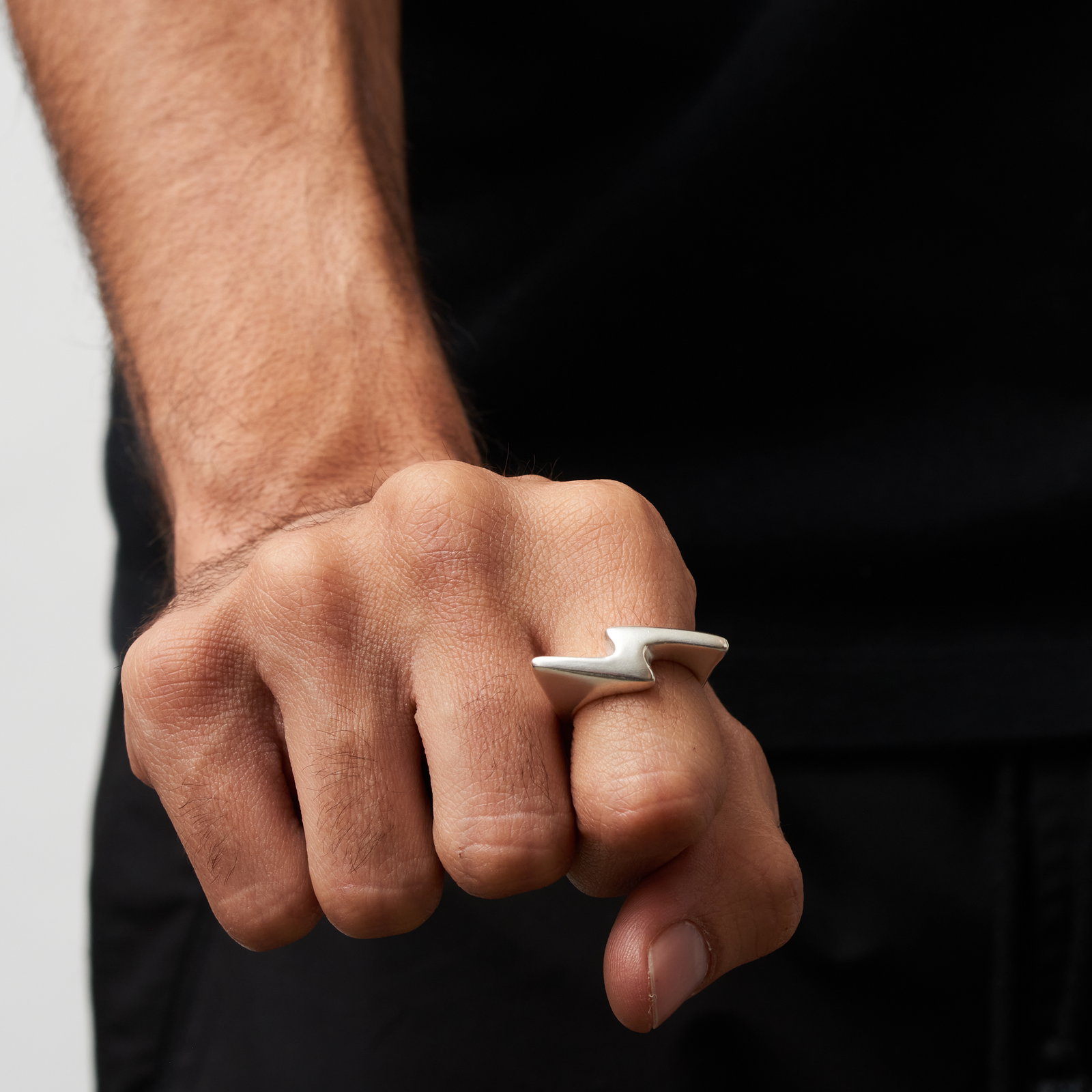 Men's hand wearing silver lighting bolt ring