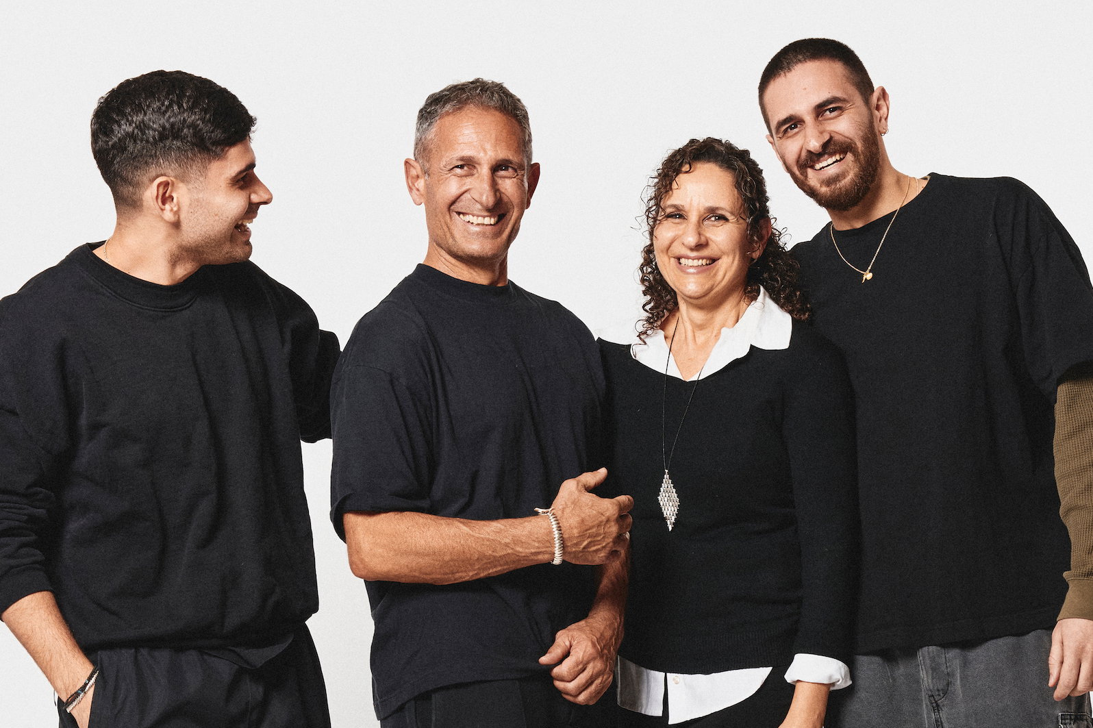 An adult family of four smiling and wearing silver jewelry