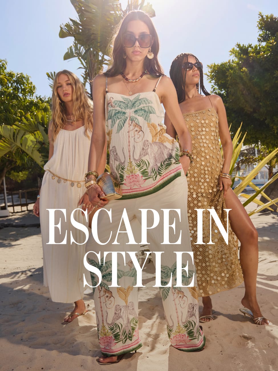 Three women model summer holiday outfits on a sunny tropical beach, wearing flowing maxi dresses, a printed co-ord set, and a gold embellished dress. Palm trees and bright sunshine create a luxury resort backdrop, with the text “Escape in Style” overlaid across the image.