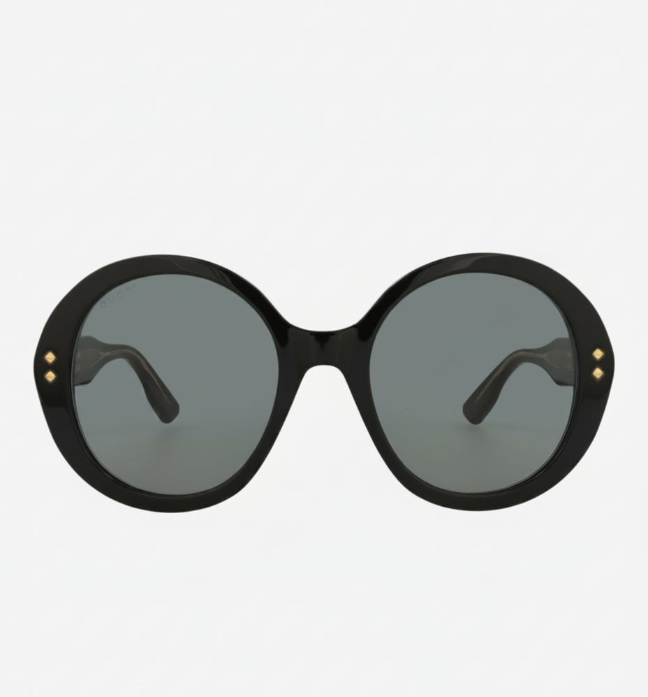 Black oversized oval sunglasses with gold stud accents.