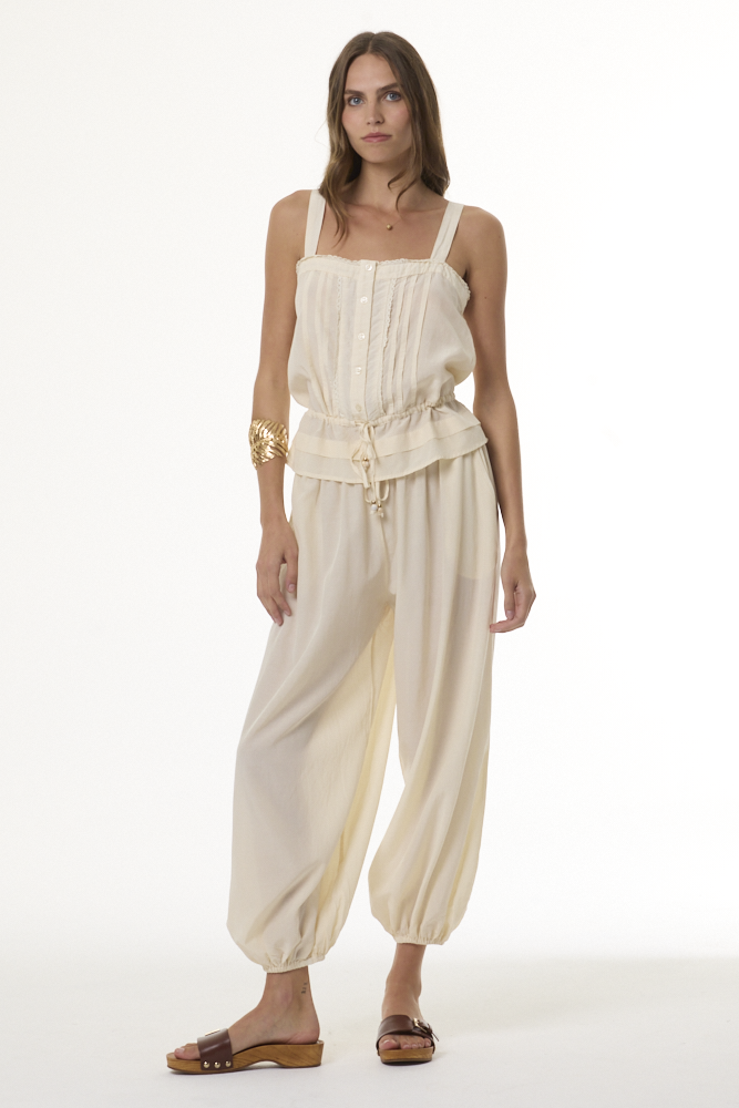 Woman wearing cream colored cami tank and matching harem pants